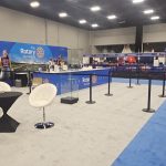 Open convention space featuring Rotary Foundation branding, information counters, and seating installed on the show floor.