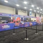 Registration and service counters with full event branding installed for the Rotary International Convention inside a large convention hall.